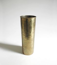 a metal cup sitting on top of a white table