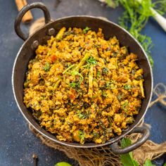 a pan filled with food sitting on top of a blue counter next to some vegetables