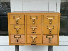 an old wooden file cabinet with brass handles and knobs on it's sides