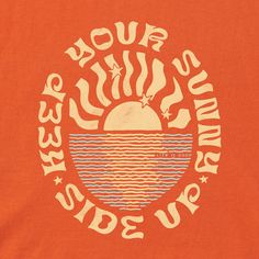 an orange tshirt with the sun rising over water and stars in the sky