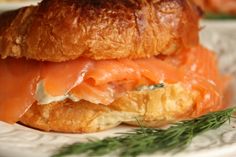 a close up of a sandwich on a plate with some dill sprig