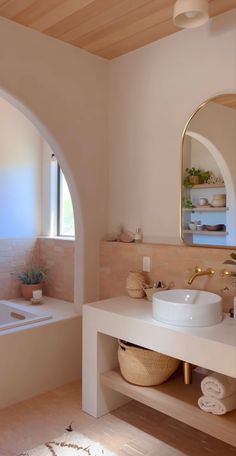 a white sink sitting under a mirror in a bathroom next to a bathtub and window