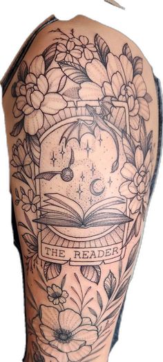 the back of a woman's shoulder with flowers and an open book on it