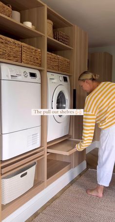 a woman is looking at the washer and dryer