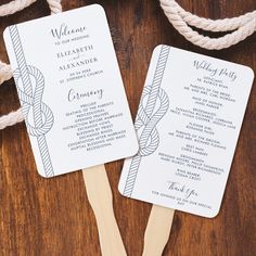 two wedding program fans on top of a wooden table next to twine ropes and rope