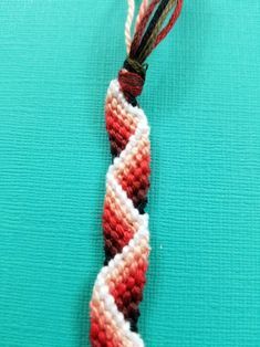 a red and white piece of string with two strings attached to it on a blue surface