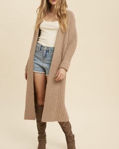 The Fireside Knit Duster is a slightly oversized fit. This is a thick knit cardigan with folded sleeves. 47% Polyester, 26.5% Acrylic, 26.5% Nylon. Model is wearing a size Small.