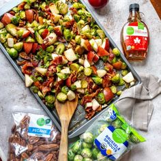 a pan filled with brussel sprouts, apples and bacon next to other ingredients