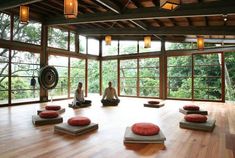 two people sitting in a room with yoga mats on the floor