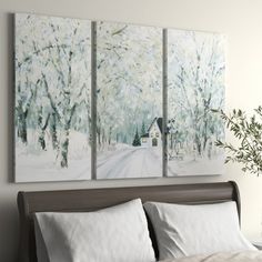 three paintings hang on the wall above a bed