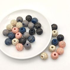 a white plate topped with lots of different colored beads