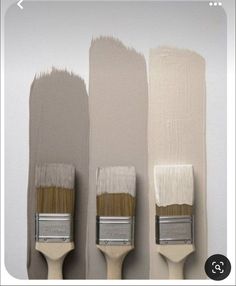 three paintbrushes with different shades of white and beige on them, one is brown