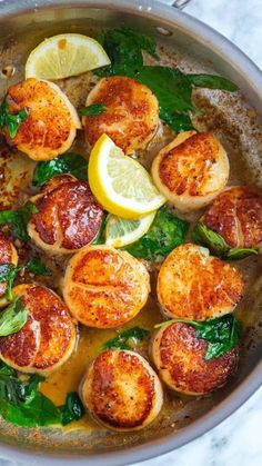 cooked scallops with spinach and lemon in a pan