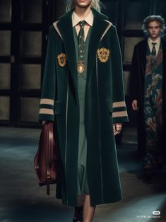 a model walks down the runway in a green coat and dress with gold details on it