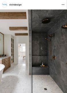 a bathroom with marble walls and flooring next to a bathtub in the corner