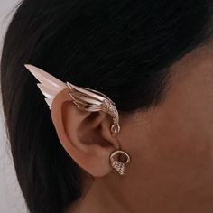 a close up of a person wearing an ear with two wings on top of it