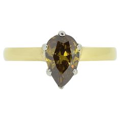 a yellow and white gold ring with a pear shaped brown diamond on it's side