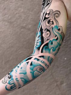 the arm is covered in blue and black ink with an intricate design on it's arm