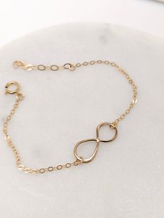 "Our gift to you 10% off your first purchase. Details here - http:/eepurl.com/dpVPBz A meaningful charm bracelet. The dainty infinity symbol is suspended from our signature dainty but strong chain. Ideal for everyday wear and makes a thoughtful gift for that someone special. DETAILS 14 k fill or Sterling Silver Infinity charm measures 3/4\" Beautiful and dainty chain Comes with a 1\" extender chain to fine tune your fit This listing is for one infinity bracelet only FIND THE PERFECT FIT - MEASUR Infinity Bracelets, Bracelet For Mom, Eternity Bracelet, Gold Lariat Necklace, Dot Necklace, Couples Bracelet, Infinity Charm, Dainty Chain, Crescent Moon Necklace