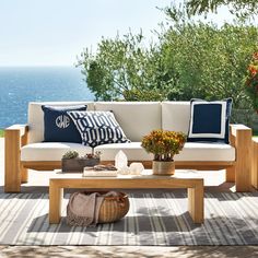 a couch and table on a patio overlooking the ocean