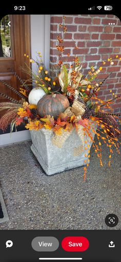 an image of a vase with autumn flowers in it on the front steps of a house