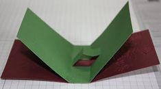 an origami box with red and green paper