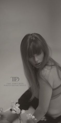 a black and white photo of a woman kneeling down with flowers in her hand on the floor