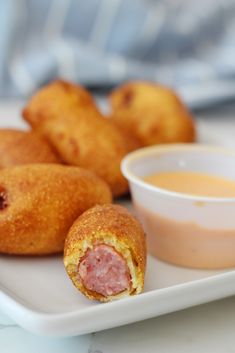 some food on a white plate with dipping sauce