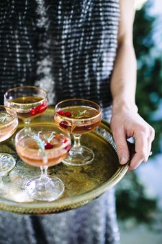 a person holding a tray with three glasses on it and the caption says glitter guide 5 holiday hostess tips