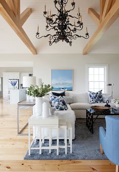 a living room filled with furniture and a chandelier hanging over the top of it