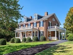 a large brick house with lots of windows and balconies on the second story