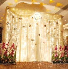 a wedding stage decorated with flowers and lights