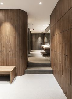 a bathroom with wooden cabinets and a bench in the middle, along with white carpeting