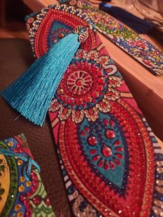 two colorful ties with tassels on them sitting on a table next to other items