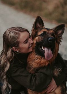 a woman is hugging her german shepherd dog