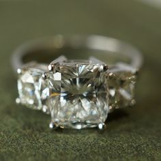 two diamond rings sitting on top of a green surface