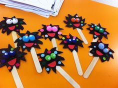 a group of toothpicks decorated with black and red designs on them sitting on top of an orange table