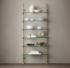 a shelf with bowls and plates on it in front of a wall mounted shelving unit