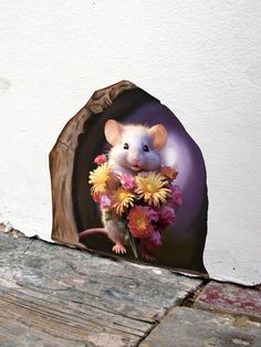 a mouse with flowers in it's mouth sitting on a piece of wood next to a wall