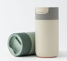 thermos cup is sitting next to the bottle on the table