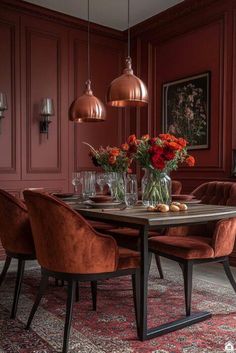 an elegant dining room with red walls and wooden furniture, along with floral centerpieces