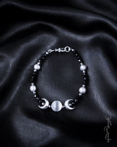 In honour of Artemis, Goddess of the wilds and Goddess of the moon. She who wears the crescent moon crown. An enchanting beaded bracelet featuring a Selenite sphere framed by crescent moons, and strung between black Onyx and silver freshwater pearls. This bracelet depicts the Triple Goddess symbol, the Selenite bead in the centre symbolising the full moon with a waxing and waning crescent on either side.  The crescent moon beads are produced in sterling silver and are uniquely textured by hand g Silver Spiritual Bracelets With Moon Phase, Mystical Adjustable Moon Phase Jewelry, Celestial Silver Moon Phase Bracelets, Adjustable Mystical Moon Phase Jewelry, Celestial Silver Bracelets With Moon Phase, Adjustable Moon-shaped Celestial Bracelets, Adjustable Moon Shape Celestial Bracelets, Spiritual Moon Phase Bracelet Jewelry, Spiritual Moon Phase Round Bracelets