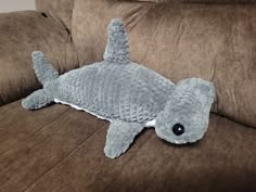 a stuffed shark laying on top of a couch