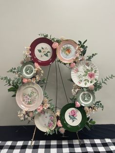 a table topped with plates and flowers on top of a black and white checkered table cloth