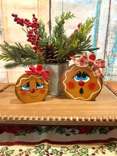 two gingerbread cookies decorated with bows sit on a table next to a potted plant