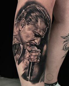 a man with a microphone tattoo on his leg