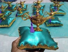 a table topped with lots of green pillows and gold figurines on top of it