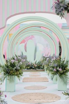 an outdoor ceremony setup with flowers and greenery in vases on either side of the aisle