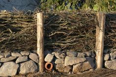 there is a pile of rocks next to a fence