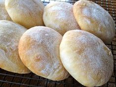 six sugar - coated doughnuts cooling on a wire rack, ready to be baked